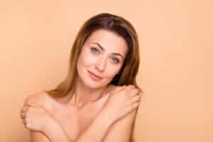 Beautiful mature woman covering her upper body with arms.
