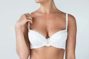 Close-up of a woman in a white lace bra, showing natural-looking breast contours after fat transfer breast enhancement
